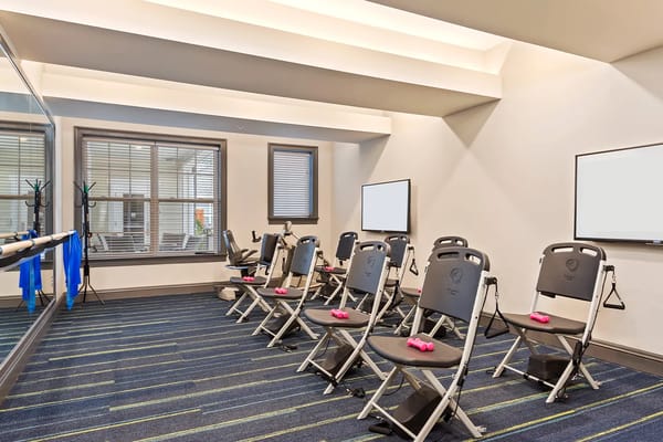 Bright fitness room with exercise equipment and light weights