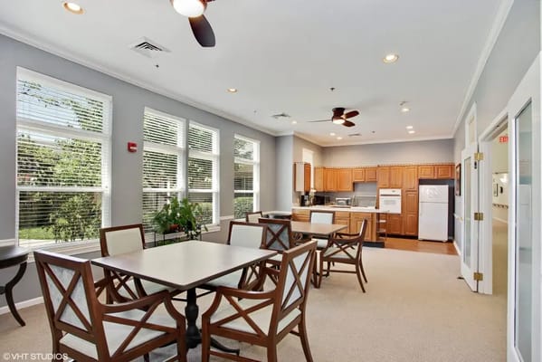 Bright dining area with tables and kitchen in background