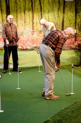 Residents enjoying indoor putting activity
