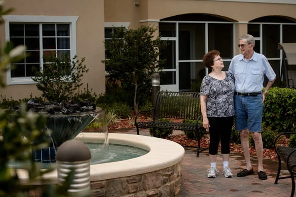 Couple standing by a decorative fountain in the garden