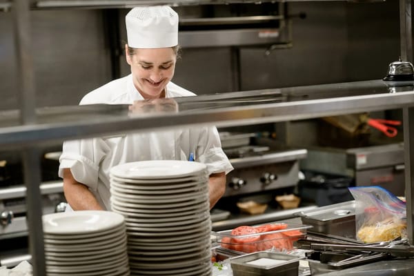 Chef smiling in a kitchen with plates
