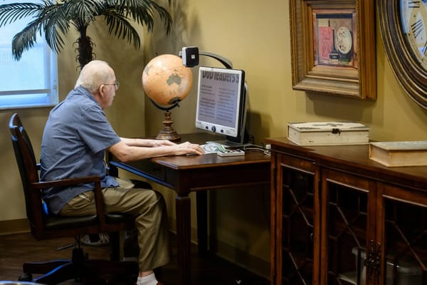 A resident using a computer at a desk.