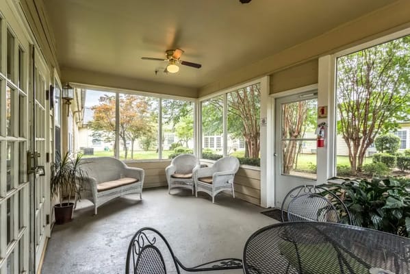 Screened porch area with seating overlooking a garden