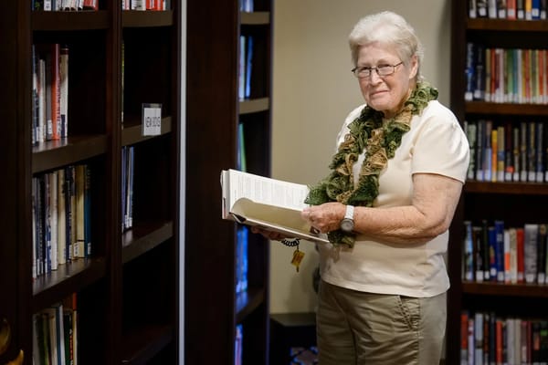Senior resident reading a book in the library