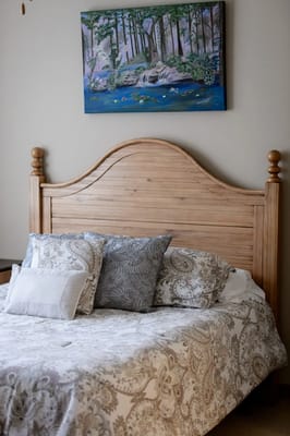Cozy resident room with a wooden bed and decorative bedding