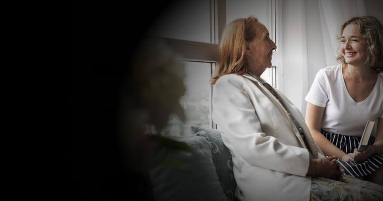 A resident and staff member engaged in conversation indoors