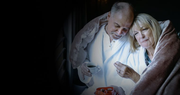 Couple wrapped in blankets, sharing a moment together