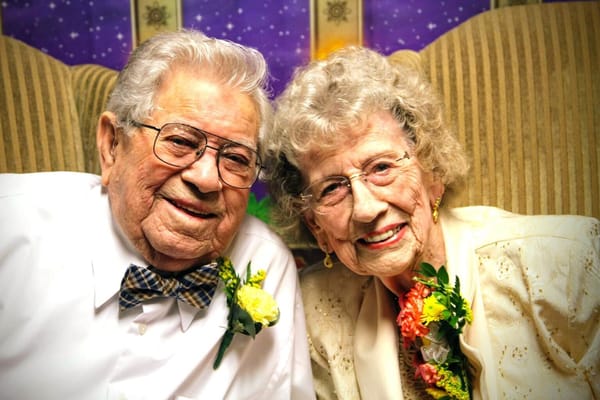 Happy elderly couple posing together with flower corsages