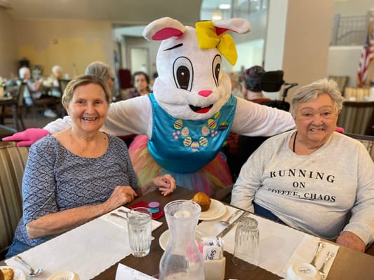 Residents enjoying an Easter celebration with a festive character