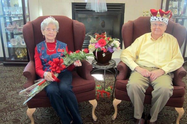 Residents celebrating with flowers and crowns in a cozy common area