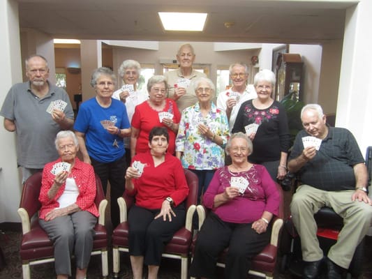 Residents gathered in a common area holding playing cards