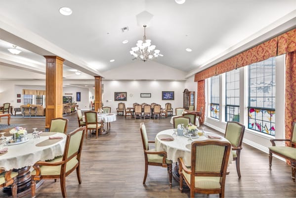 Bright dining room with tables and chairs set for a meal