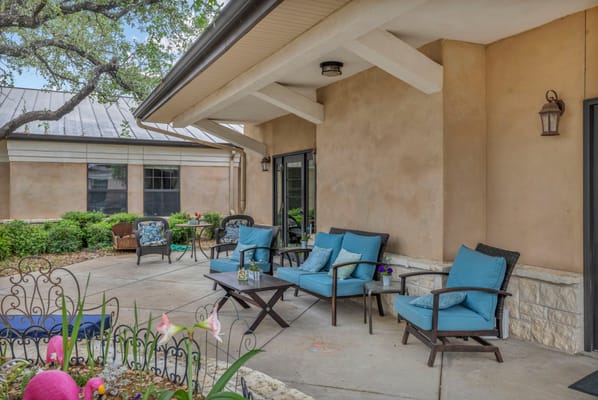 Outdoor seating area with blue chairs and flowers
