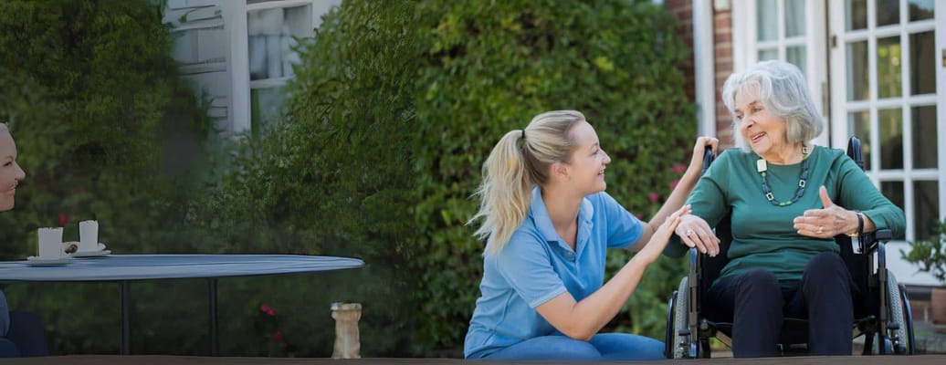 Caregiver assisting a resident outdoors.