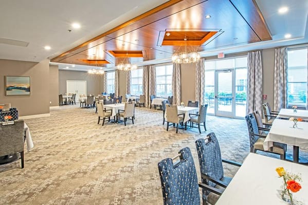 Bright dining room with tables and chairs set up