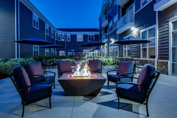 Outdoor seating area with a fire pit in the evening
