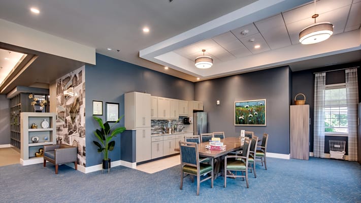 Interior view of a community common area with kitchen and dining table