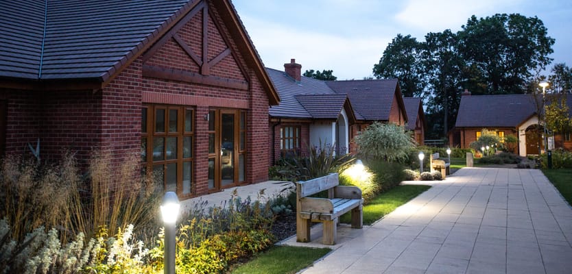 Pathway with lighting and benches outside residential buildings