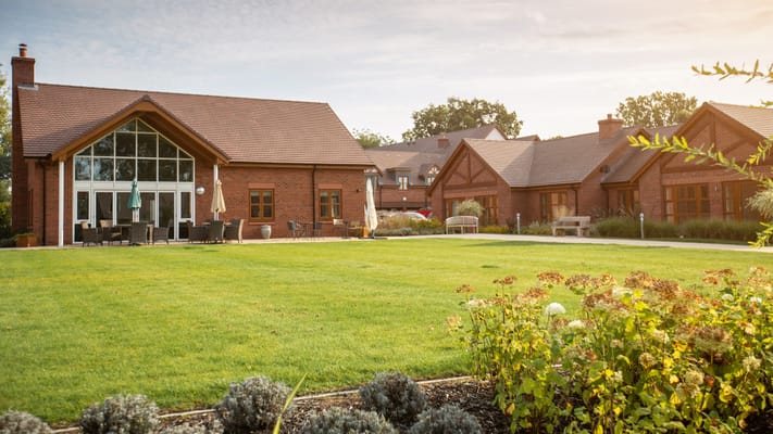 Exterior view of a senior care facility with well-maintained lawn