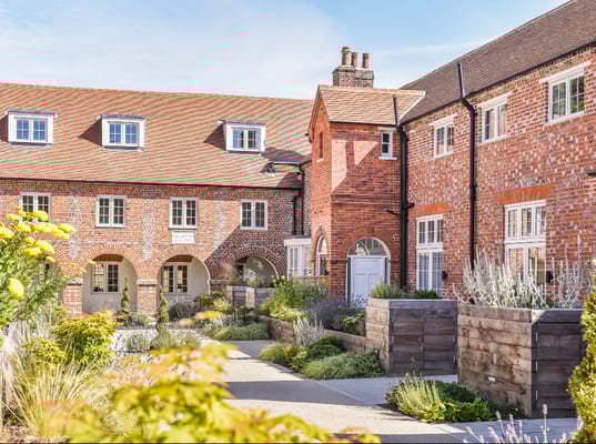 Exterior view of a senior living facility with gardens