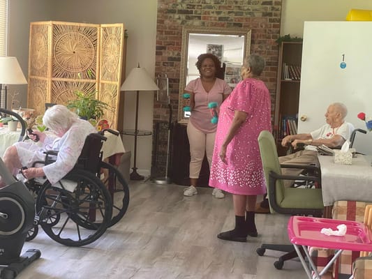 Residents participating in an indoor activity with staff assistance
