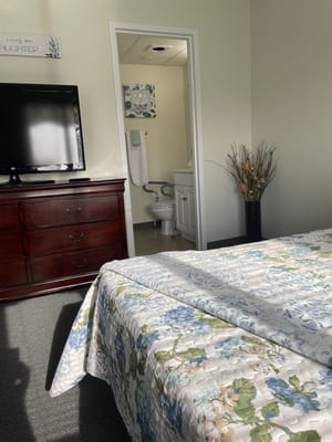 Private resident room with floral bedding and bathroom