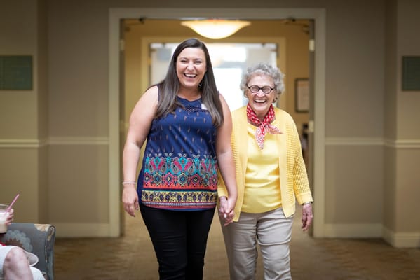 Staff member and resident walking together in a hallway