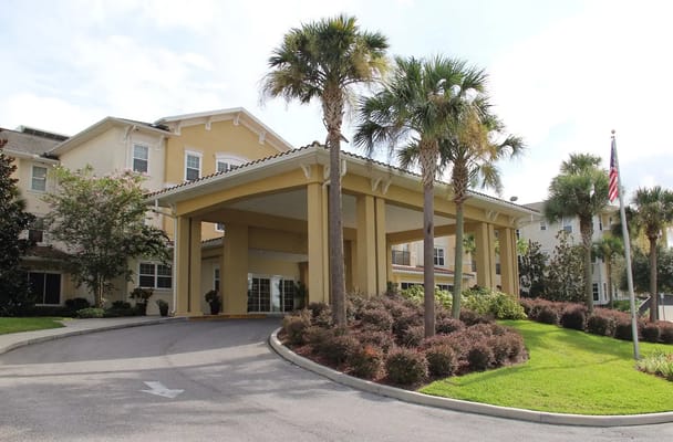 Entrance of American House Zephyrhills with palm trees