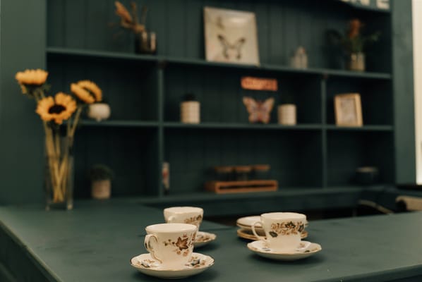 Decorative tea cups on a green counter in a common area