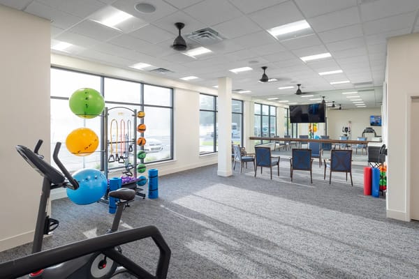 Spacious fitness room with exercise equipment and seating