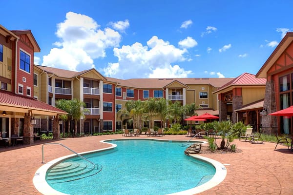 Outdoor pool area with seating and palm trees