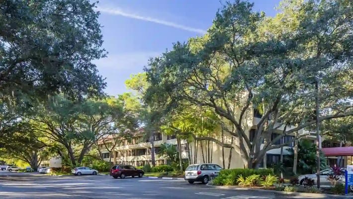 View of the facility's exterior with trees and parking