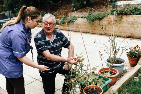Staff assisting a resident with gardening