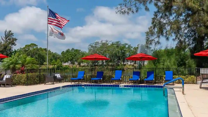 Outdoor pool area with lounge chairs and umbrellas