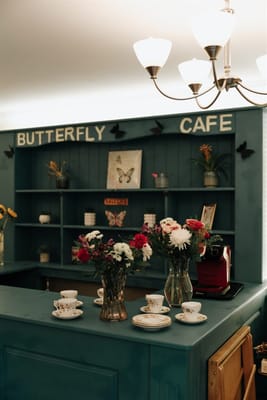 Interior cafe area with floral arrangements and teacups