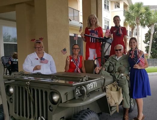 Staff and residents celebrating with a vintage military vehicle
