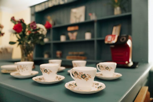 Elegant tea setup with floral decor and coffee machine
