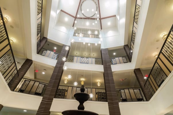 Interior view of a multi-story atrium with lighting fixtures