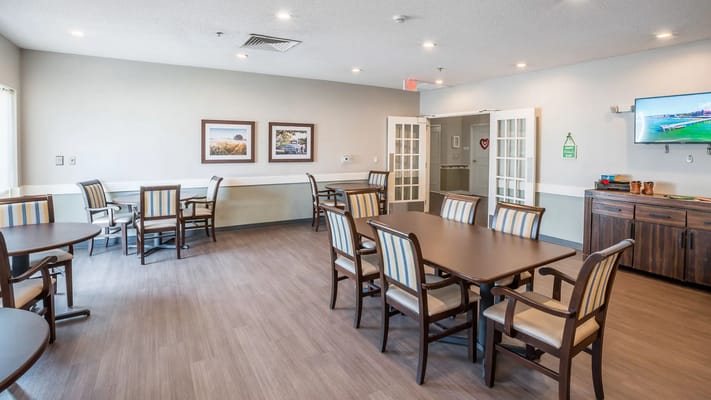 Common area with tables and chairs in a bright room