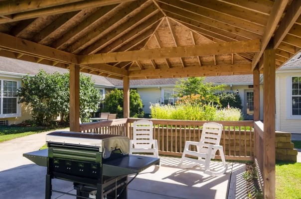 Outdoor gazebo area with seating in a landscaped garden