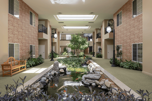 Bright indoor courtyard with greenery and a water feature
