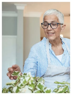 Senior woman tending to plants indoors