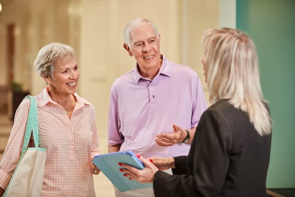Residents engaging in conversation with staff in the lobby