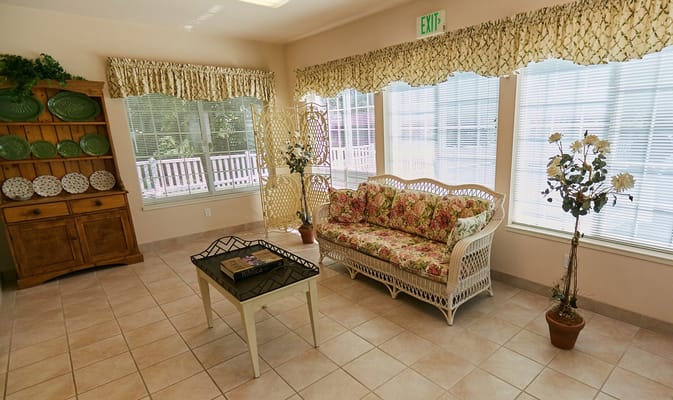 Bright common area with floral furniture and large windows