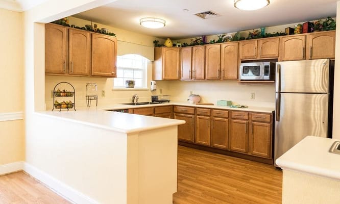 Bright kitchen area with wooden cabinets and appliances