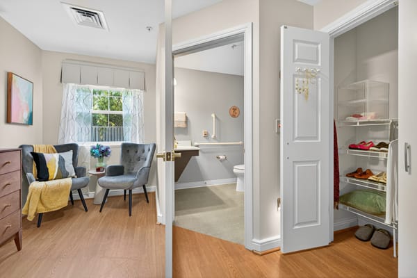 A private resident room with seating and storage