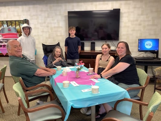 Residents and staff enjoying a social activity at a table