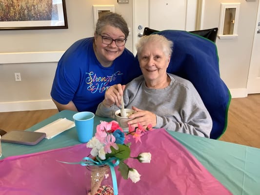Resident enjoying ice cream with a staff member