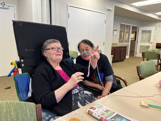 Residents engaged in a craft activity in a community room