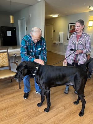 Resident interacting with a dog in a common area